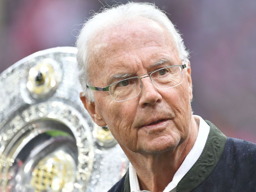Franz Beckenbauer mit Meisterschale im Hintergrund