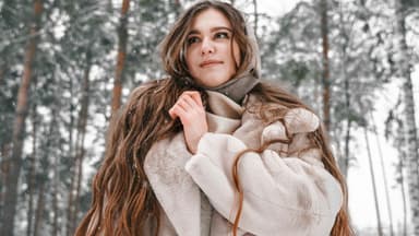 Frau mit sehr langen Haaren im Winterwald