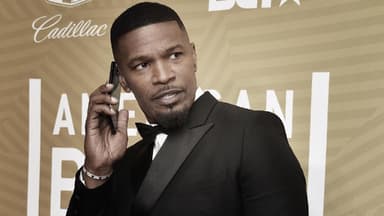 Jamie Foxx hält sich ein Handy ans Ohr und sieht ernst zur Seite