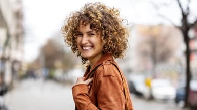 Auch bei kurzen Haaren kannst du mit einem Lockenstab einen Cury-Girl-Look zaubern.