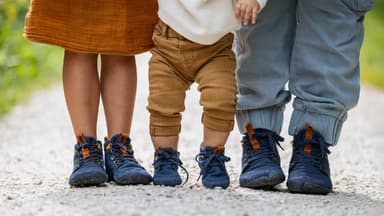 Drei Kinderfüße mit Barfußschuhen von Wildling