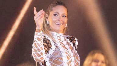 Helene Fischer hebt lächelnd die Hand bei Konzert