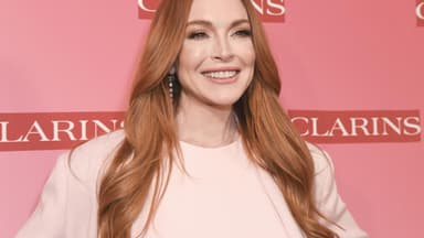 Lindsay Lohan strahlt vor pinkem Hintergrund