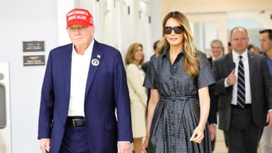 Donald & Melania Trump gehen nebeneinander, Menschen im Hintergrund