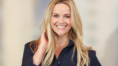 Reese Witherspoon Hand am Haar lächelt