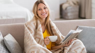 Frau mit Decke auf Sofa