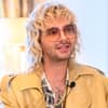 Bill Kaulitz sitzt auf einer Couch