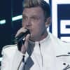 Nick Carter guckt ernst mit Mikrofon in der Hand