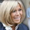 Brigitte Macron lacht fröhlich - im Hintergrund in Jeans vorm Elysée Palast