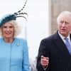 König Charles und Königin Camilla lächeln in Kamera