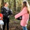 sturm der Liebe Vroni und Valentina stehen mit ihren Motorradhelmen in der Hand neben einem Motorrad im Wald