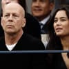 Bruce Willis guckt ernst, neben ihm sitzt seine Ehefrau Emma