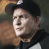 Charlie Sheen trägt eine Cap und einen Hoodie, sieht betroffen zur Seite