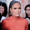 Jennifer Lopez geht in einem roten Glitzerkleid durch eine Menschenmenge