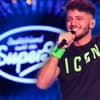 Momo Chahine mit Mikrofon in der Hand vor DSDS-Logo