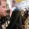 Prinz Harry von der Seite, daneben Harry und Meghan mit Fotografen