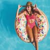 Frau im Badeanzug schwimmt auf Donut