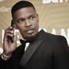 Jamie Foxx hält sich ein Handy ans Ohr und sieht ernst zur Seite