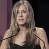 Jennifer Aniston steht mit traurigem Gesichtsausdruck am Mikrofon