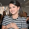 Selena Gomez grinst und fasst sich ans Herz