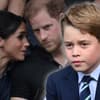 Herzogin Meghan und Prinz Harry tuscheln, im Vordergrund sitzt Prinz George