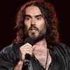 Russell Brand spricht ins Mikrofon und sieht verärgert aus