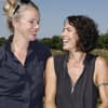 Ulrike Folkerts und Partnerin Katharina Schnitzler sehen sich an und lachen.