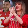 Travis Kelce lächelt, Taylor Swift applaudiert