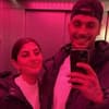 Yeliz Koc und Yasin Mohamed machen ein Spiegelselfie bei rosa Licht