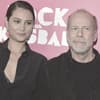 Emma Heming-Willis und Bruce Willis posieren vor einer pinken Wand