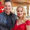 Andreas Gabalier und Silvia Schneider mit einem Strauß roter Rosen