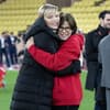 Fürstin Charlène und Prinzessin Stéphanie umarmen sich bei einem Fußballspiel. 