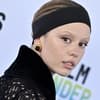 Mia Goth blickt von der Seite in die Kamera, Mund ist leicht geöffnet