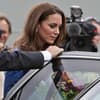 Prinzessin Kate steigt in ein Auto, ein Sicherheitsmann hält ihr die Tür auf. Im Hintergrund haben sich Paparazzi versammelt.