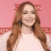 Lindsay Lohan strahlt vor pinkem Hintergrund