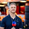 Ralf Schumacher lächelt mit Mikrofon von der Hand