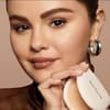 Selena Gomez mit Puder in der Hand