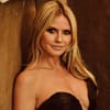 Heidi Klum lehnt an brauner Wand