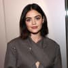 Lucy Hale steht vor einer Wand & guckt in die Kamera