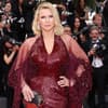 Veronica Ferres in einem dunkelroten Glitzerkleid bei einem Event, Fotografen im Hintergrund