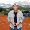 Hans Sigl vor Bergkulisse auf Tennisplatz