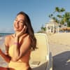 Frau cremt sich am Strand ein