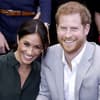 Herzogin Meghan lehnt sich lachend an Prinz Harry