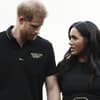 Prinz Harry sieht zu Boden, Herzogin Meghan sieht in fordernd an