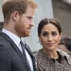 Prinz Harry schaut ernst, Ehefrau Meghan sieht ihn fragend an