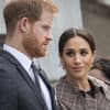 Prinz Harry schaut ernst, Ehefrau Meghan sieht ihn fragend an