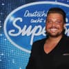Menowin Fröhlich vor dem DSDS-Logo