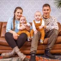 Sarafina und Peter Wollny sitzen mit ihren Zwillingen Emory und Casey auf dem Sofa.