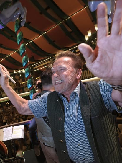 Arnold Schwarzenegger dirigiert im Marstall-Zelt die Kapelle auf der Wiesn