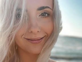 Anna Heiser mit blonden Haaren lächelt am Meer